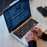 Hands using payroll software on a laptop